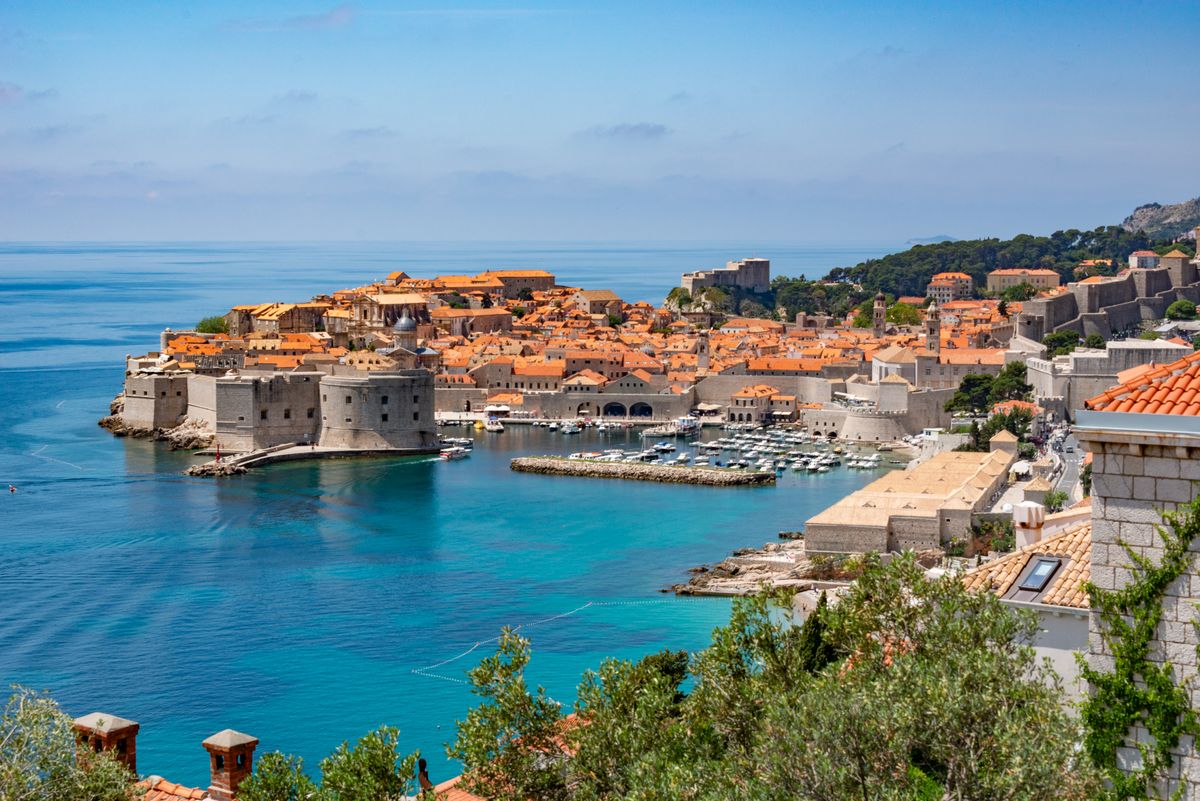 Walled old town of Dubrovnik with orange roofs beside the turquoise Adriatic Sea